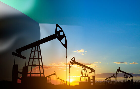 Silhouette of oil pump jacks with Kuwait flag against the sunset or sunrise. Kuwait Oil Industry concept