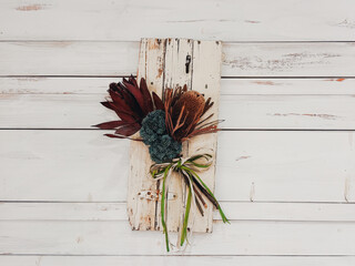 アンティーク調の白いウッドパネルに飾られたワイルドフラワーのスワッグ