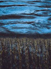 A close-up of water dropping off a weir or waterfall