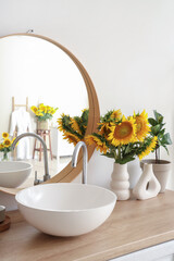 Sink, mirror and sunflowers in bathroom. Closeup