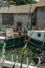Fototapeta premium Fishing boats and rods docked by shanties in Fishtown, Leland