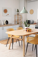 Interior of stylish kitchen with dining table, chairs and lamp
