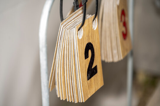 Numbered wooden tags hanging on hooks in a storage or organization system