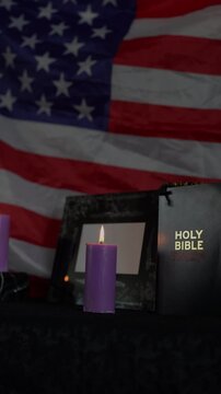     funeral of an American hero, photo frame, candles, a marble urn for ashes, holy bible and spiritual bracelet with black cross