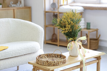 Vase with beautiful mimosa flowers on table in living room