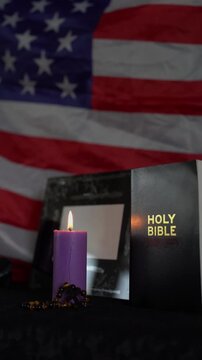     funeral of an American hero, photo frame, candles, a marble urn for ashes, holy bible and spiritual bracelet with black cross
