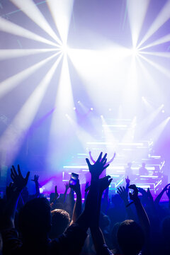 Cheering crowd with hands raised at concert. Summer and festival vibes