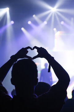 Cheering crowd with hands raised at concert. Summer and festival vibes