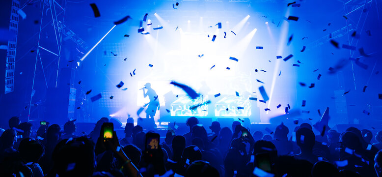 Cheering crowd with hands raised at concert. Summer and festival vibes
