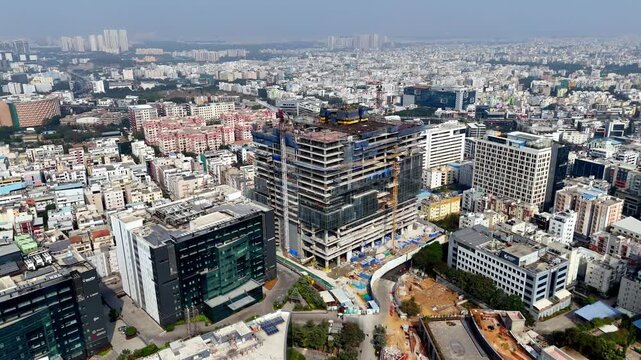 Steel, glass, and cranes shape the future&mdash;an aerial of a landmark tower under construction amid HITEC City&rsquo;s thriving business district. Dense urban setting transitioning to modern city center.