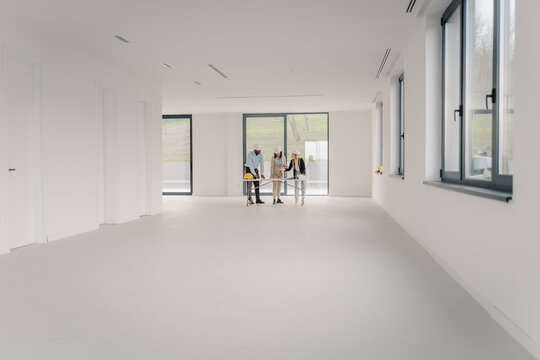 Architecture team discussing project in empty office space