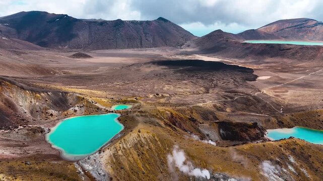 Blue crater lakes with fumeroles in rugged Tongariro Alpine Crossing, aerial