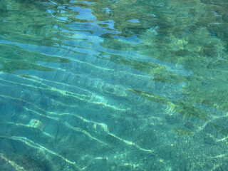 Naklejka premium Crystal clear seawater with pebbles at the bottom of Mediterranean sea.