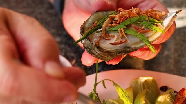 Close Up of Hands Garnishing Fresh Thai Oyster with Herbs