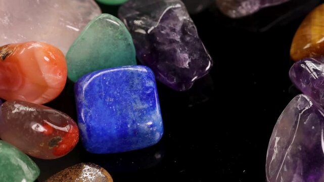 Close Up of Polished Healing Crystals Falling on Black Surface