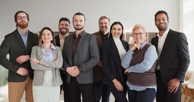 Team group people portrait in business office. Smiling happy colleagues pose after meeting, showing confidence, unity and cooperation in a bright modern workspace. Concept of teamwork and success.
