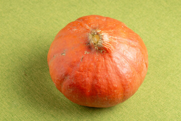 Orange pumpkin on a wooden cutboard, with a kitchen knife