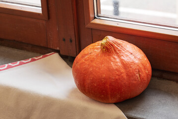 Orange pumpkin close to the window