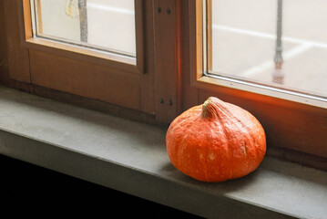 Orange pumpkin close to the window in a little country village
