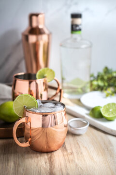 Moscow mule cocktail in copper mug preparing with lime