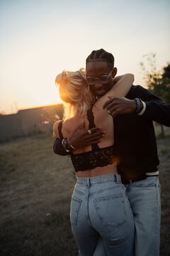 Young couple dancing together outside at sunset