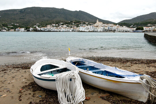 Fishing boats on beach with coastal village backdrop