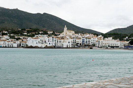 White coastal village with church and mountains