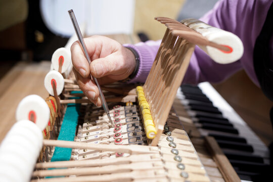 Technician adjusting piano action with screwdriver