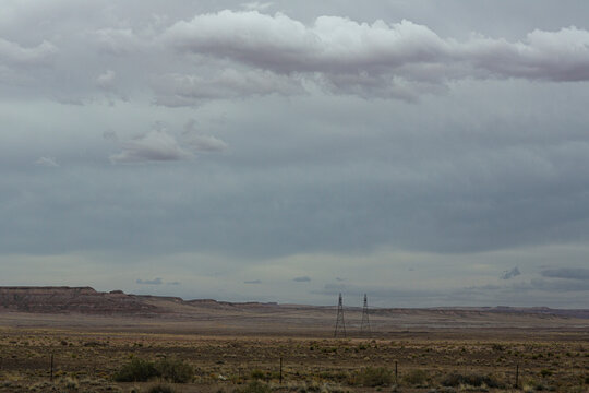 Distant high voltage towers in vast barren landscape