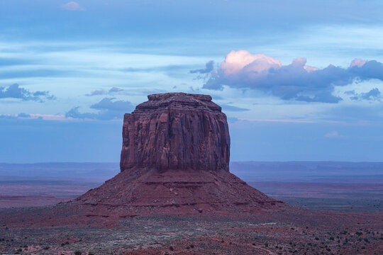 Monolithic rock formation in barren landscape at dusk