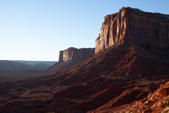 Looming sheer cliffs in vacant desert landscape