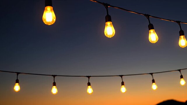 Outdoor string lights illuminating twilight sky at sunset