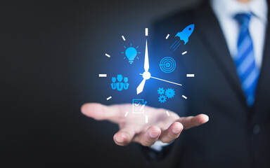 Businessman hand holding clock and business strategy icons, Business time management and business plans concept