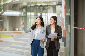 Obraz premium Business people creative talking discussion ideas in front of modern business building. Concept of teamwork and corporate success.
