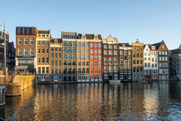 Naklejka premium Canal houses in amsterdam creating a classic european cityscape, reflecting vibrant architecture and historical charm on calm water, inviting tourism and travel exploration