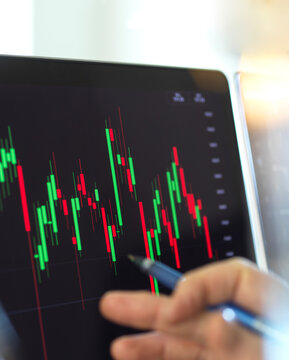Close-up of broker hand and computer monitor with graph