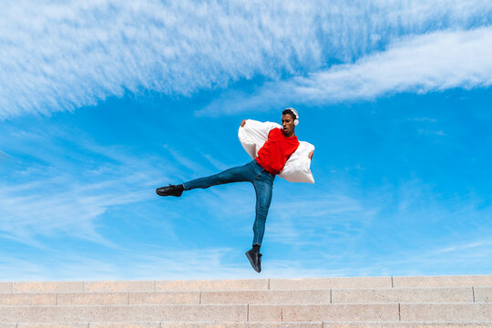 Young man moving and dancing on stairs outdoors