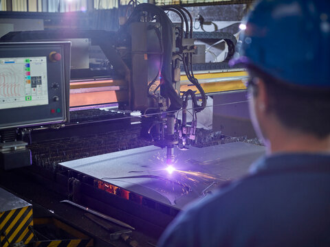 Worker looking to laser cutter