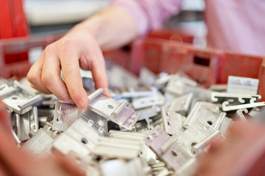 Close-up of man's hand in box with workpieces
