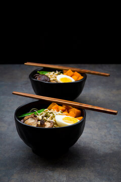 Ramen with noodles, egg, hokkaido pumpkin, mung sprout, shitake mushroom in bowl, chopsticks