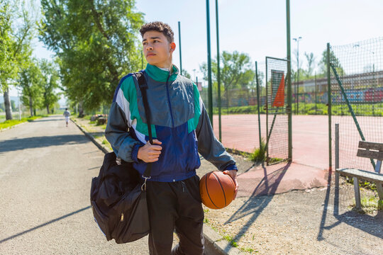 Young man with basketball at basketball court