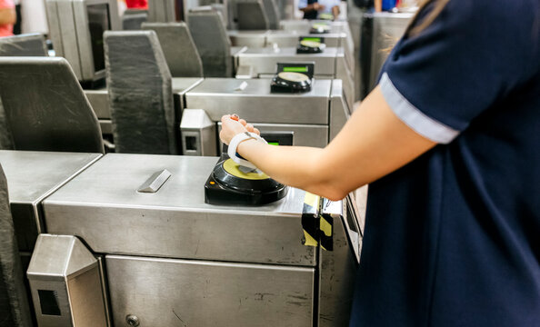 Young woman paying with her smartwatch on the subway, partial view