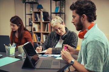 Obraz premium Diverse Creative Team Collaborating in a Modern Startup Office During a Brainstorming Session with Laptops and Notebooks