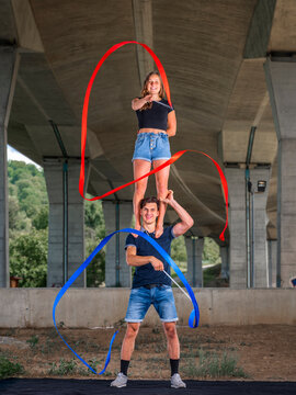 Young couple doing acrobatics with fitness band