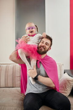 Father and daughter playing superhero and superwoman
