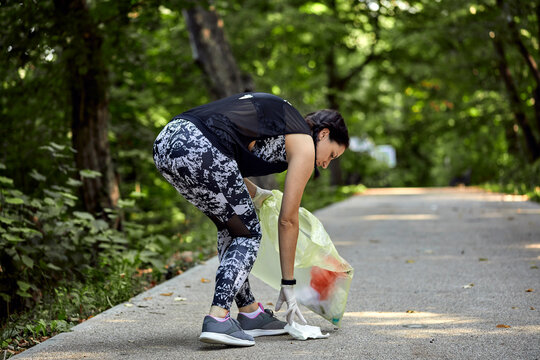 Young woman plogging on forest path