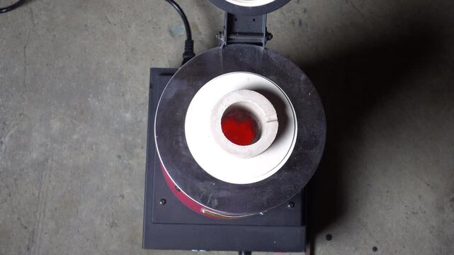 Crucible glows red with melting borax inside.
