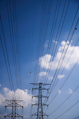 Obraz premium High Voltage Transmission Towers Against Blue Sky