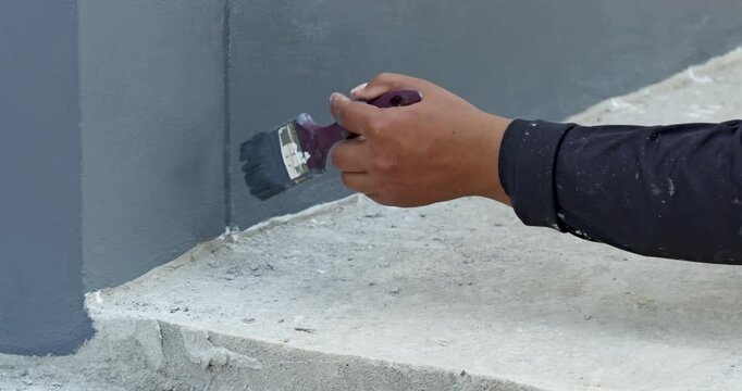 A focused look at meticulous process of painting a wall corner in a DIY home renovation.