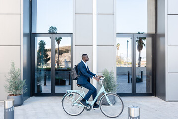 Fototapeta premium African american businessman riding a bicycle to work, sustainable transportation